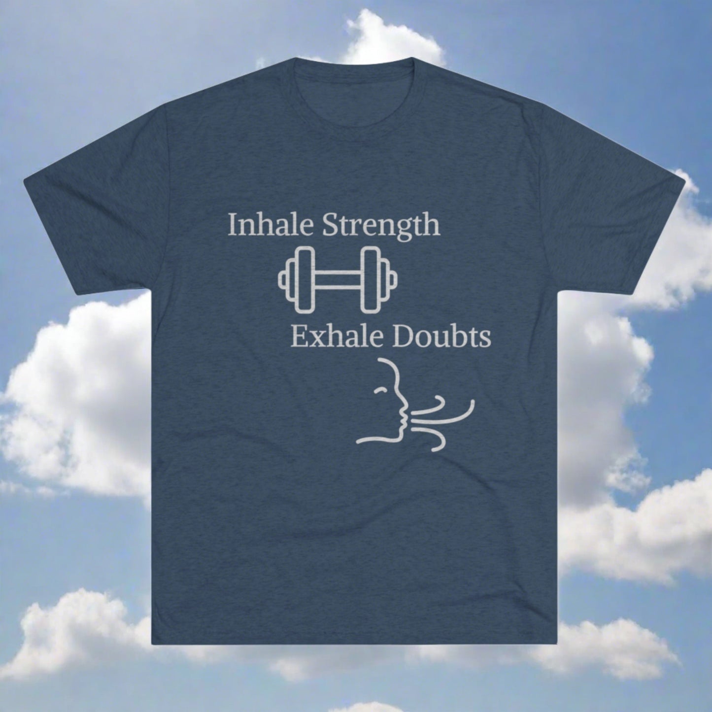 A gray motivational Printify T-shirt with the brand name "Inhale Strength Exhale Doubt w Images" in white text, featuring a dumbbell image and a simple drawing of a face exhaling, set against a blue sky