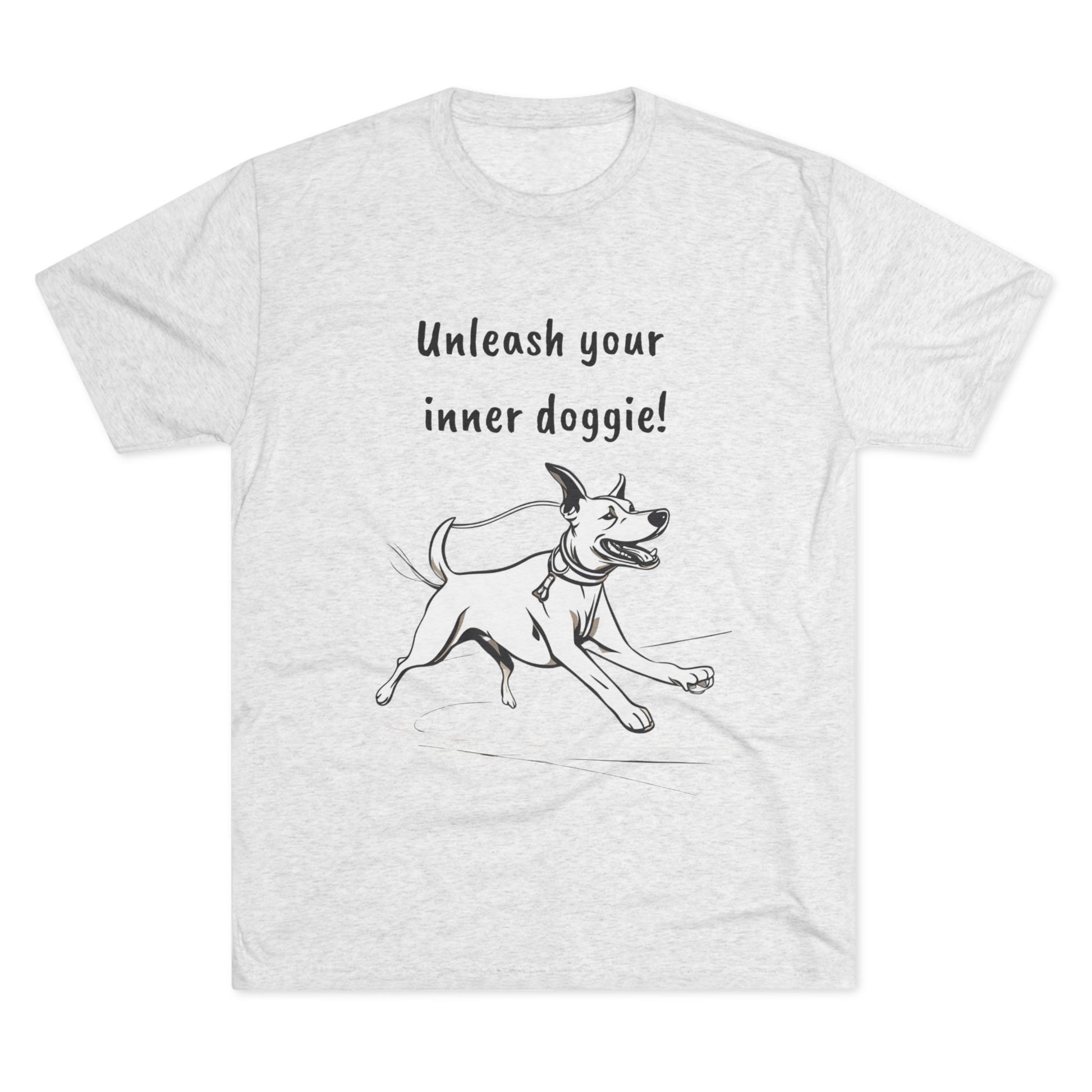 Printify's "Unleash your inner doggie - Tri-Blend Crew Tee - Unisex Fit" features a premium gray fabric blend, adorned with an illustration of a joyful running dog and the inspirational text, "Unleash your inner doggie!